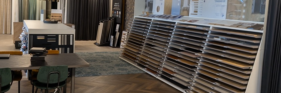 Een moderne showroom met een breed assortiment aan vloer- en gordijnstalen, overzichtelijk gepresenteerd in een sfeervolle setting.