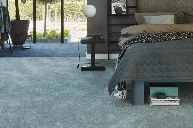 Slaapkamer met zacht blauwgrijs tapijt en modern bed in een stijlvol ingericht interieur