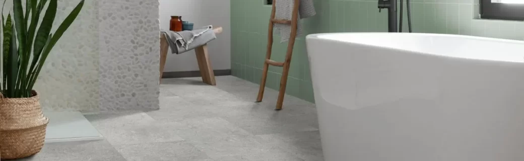 Moderne badkamer met lichtgrijze pvc tegelvloer, vrijstaand bad en groene wandtegels, afgewerkt met natuurlijke accessoires