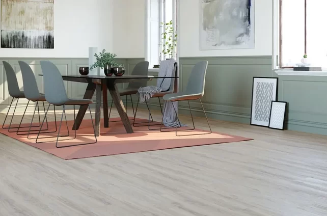 Licht eiken pvc vloer in stijlvolle eetkamer met ronde zwarte tafel, grijze stoelen en groene lambrisering