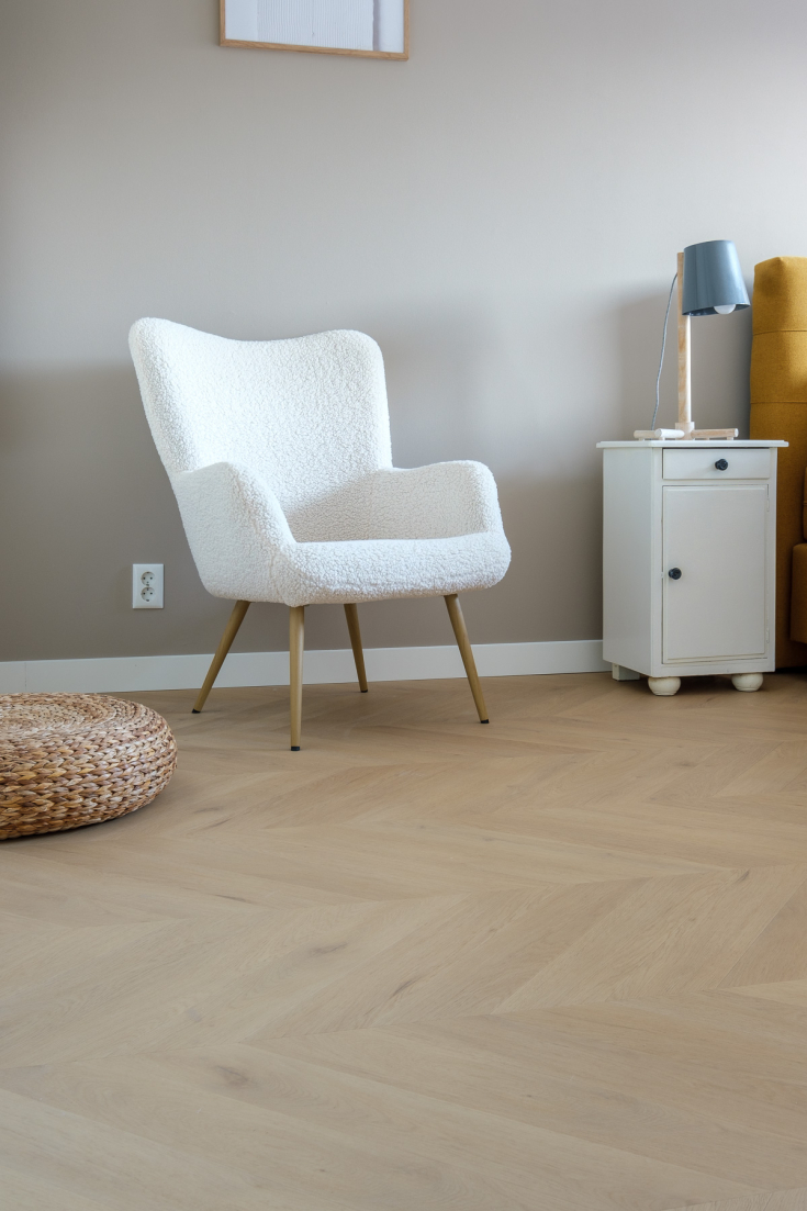 Witte stoel op een visgraatvloer