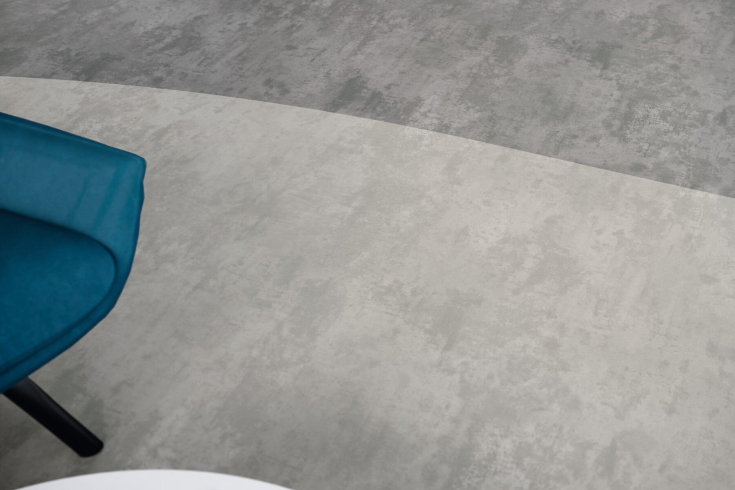 Close up van een vloer waarbij een stoel in beeld is