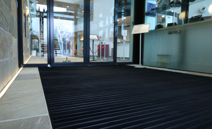 Geribbelde mat bij een toegangsdeur voor het schoonmaken van schoenen