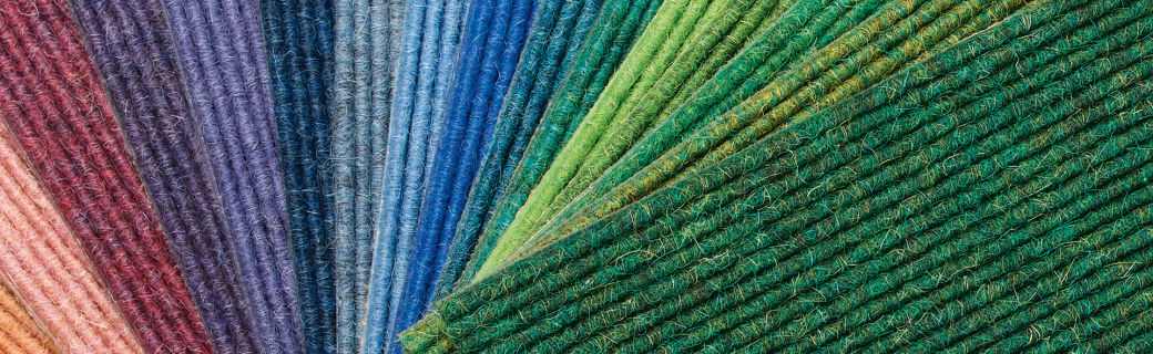 Ventilatorvormige presentatie van tapijtstalen in diverse kleuren van rood tot groen