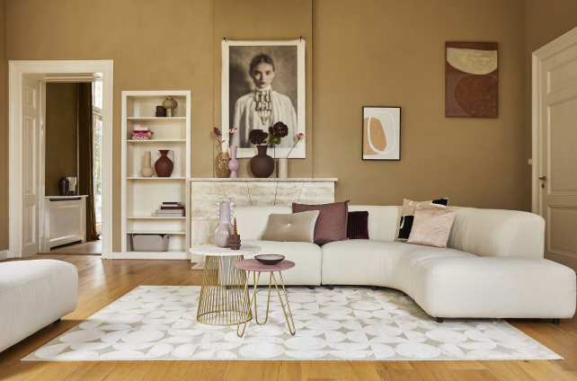 Klassiek-modern interieur met ronde hoekbank, houten vloer en licht vloerkleed met grafisch patroon