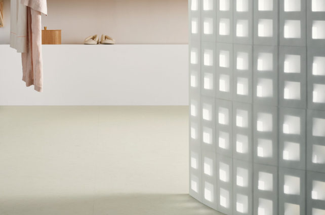 Minimalistische ruimte met licht marmoleum en opvallende gebogen wand met lichtpatroon