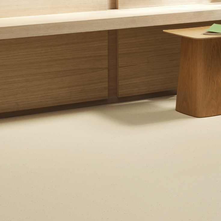 Crèmekleurige marmoleumvloer met subtiele spikkelstructuur in interieur met houten meubels