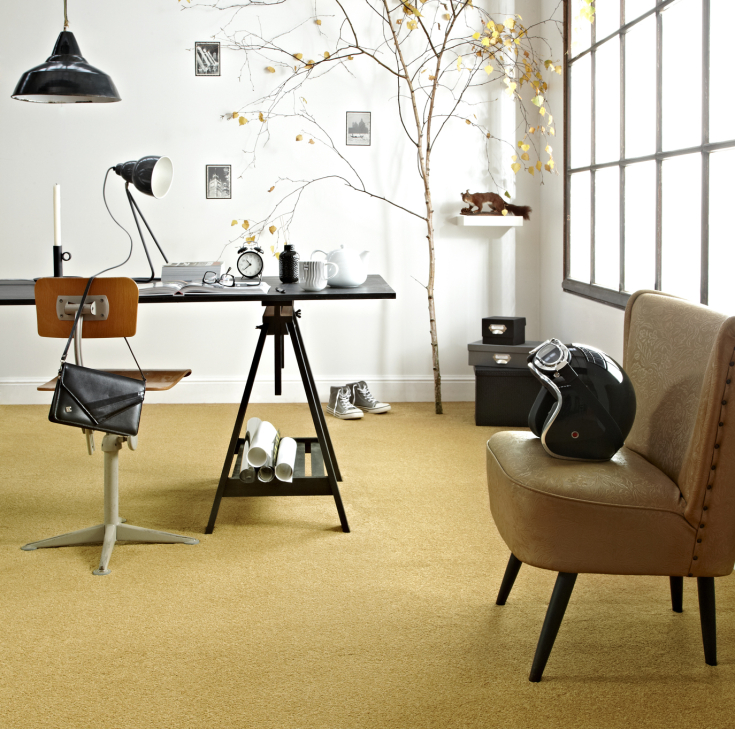 Studeerkamer met warmgeel tapijt, retro bureaustoel en natuurlijke lichtinval door grote industriële raampartij