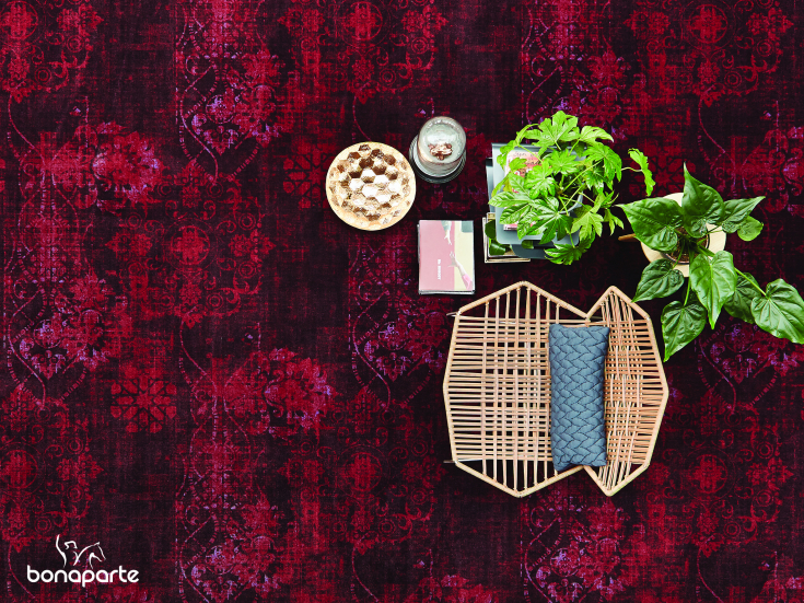 Diep rood vintage tapijt met oosterse motieven en decoratieve accessoires van bovenaf gezien