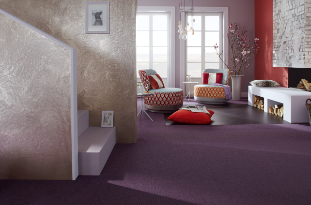 Sfeervolle woonkamer met paars tapijt, kleurrijke zitmeubels en luxe afwerking in warme tinten