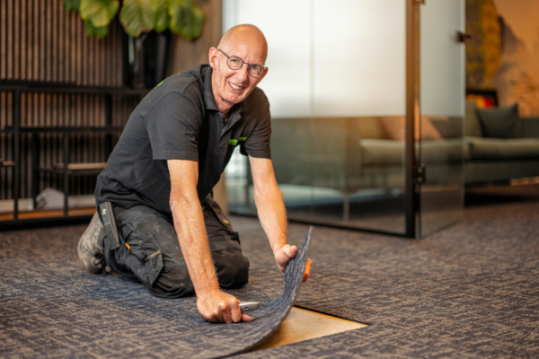 werknemer legt vloeren in een kantoor