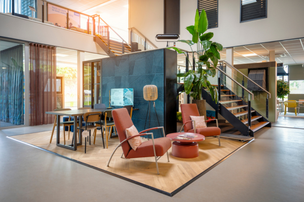 afbeelding van een showroom met twee comfortabele loungestoelen en een werktafel waar advies wordt gegeven