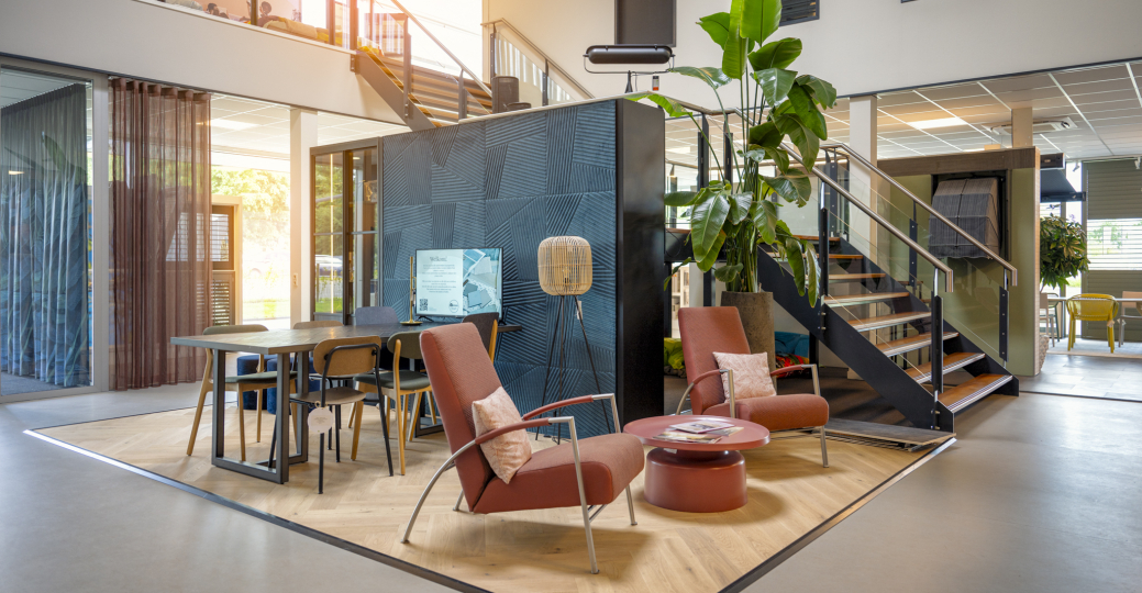 afbeelding van een showroom met twee comfortabele loungestoelen en een werktafel waar advies wordt gegeven