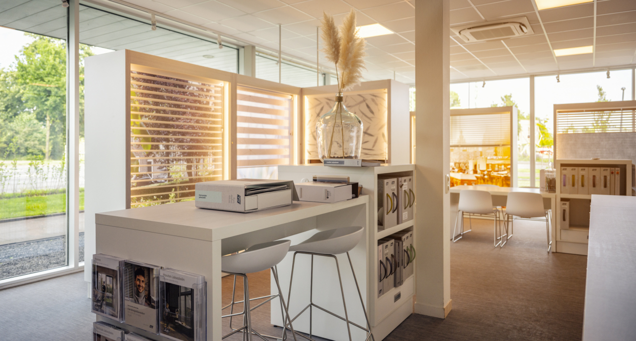 Zitgedeelte in de showroom van Deventer Vloeren met raamdecoratie en stalenkasten