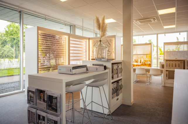 Zitgedeelte in de showroom van Deventer Vloeren met raamdecoratie en stalenkasten